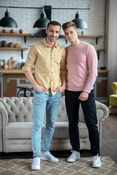 Dois jovens de pé sorrindo alegremente e parecendo bem — Fotografia de Stock