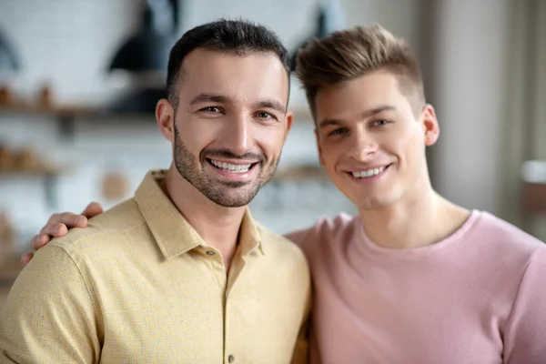 Dos jóvenes sonriendo felizmente y luciendo bien — Foto de Stock