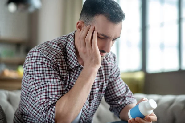 Junger Mann im karierten Hemd leidet unter Kopfschmerzen — Stockfoto