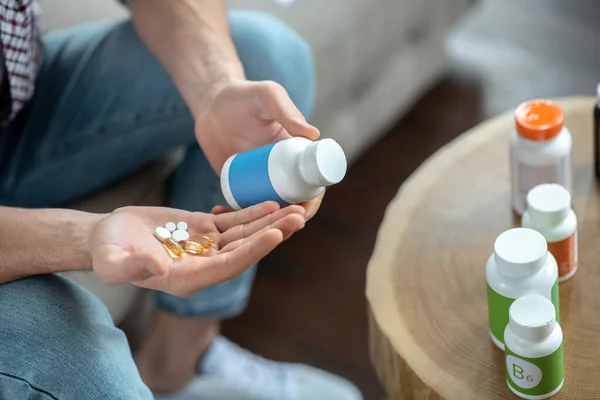 Nahaufnahme eines Mannes, der viele Tabletten in Händen hält — Stockfoto