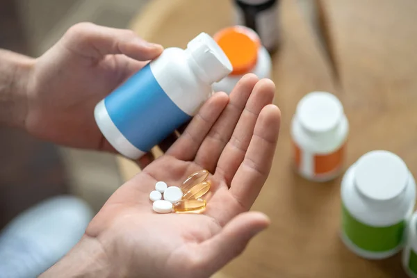 Close up picture of mans hands holding pills — Stock Photo, Image