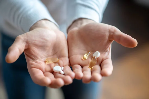 Foto ravvicinata di mani di uomo che tengono una pillola — Foto Stock