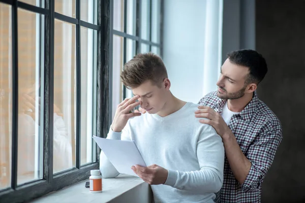Dark-haired bearded man trying to comfort his upset partner — Stock Photo, Image