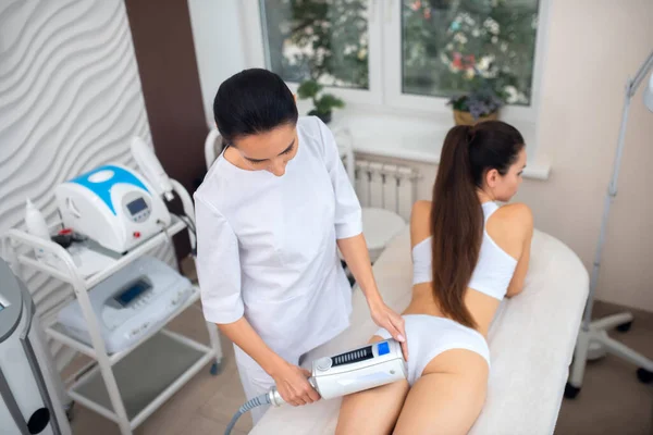 Donkerharige vrouw doet echografie massage voor constante klant — Stockfoto