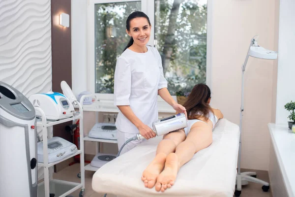 Uśmiechnięta kobieta ciesząca się pracą w klinice masażu — Zdjęcie stockowe