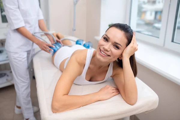 Mujer morena sonriendo mientras tiene masaje al vacío — Foto de Stock