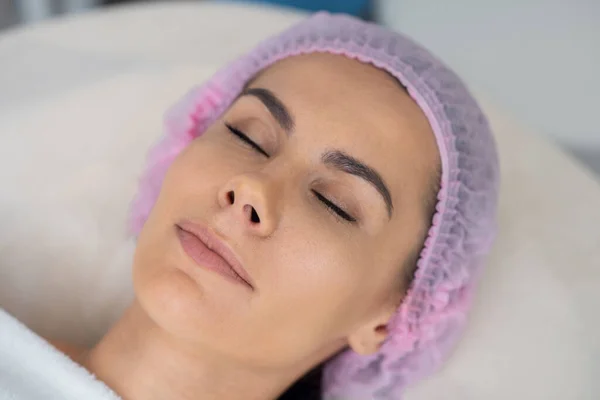 Mulher fechando os olhos antes de ter injeções de beleza — Fotografia de Stock