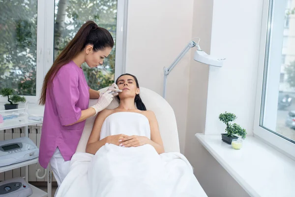 Medico di bellezza che lavora duramente mentre fa iniezioni per il cliente — Foto Stock