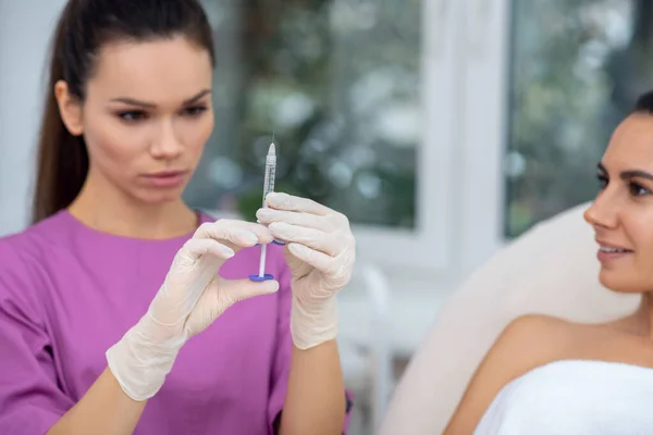 Close up of beauty doctor wearing gloves holding syringe — Stock Photo, Image