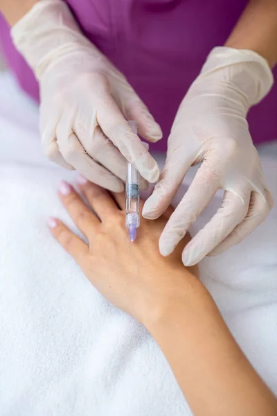 Skjønnhetslege som gir antialdring injeksjon i arm – stockfoto