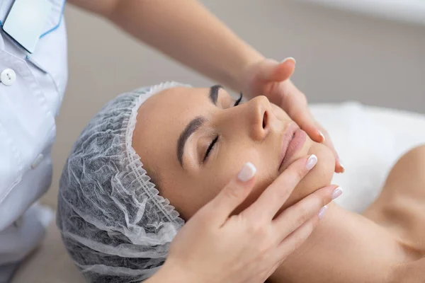 Donna chiudendo gli occhi mentre si gode il massaggio facciale — Foto Stock