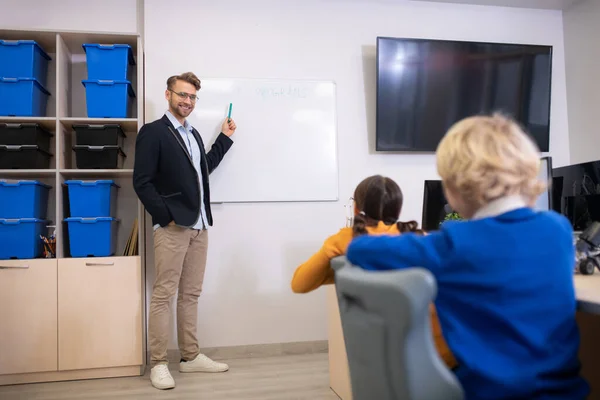 ホワイトボードに立つ男性教師、生徒へのプログラミングを説明する — ストック写真