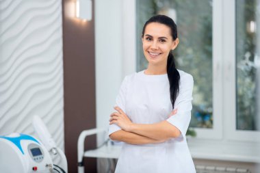 Nitelikli kozmetolog müşterileriyle konuşmadan önce gülümsüyor.