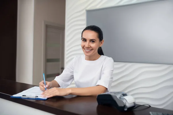 Bella amministratrice dagli occhi scuri della clinica di bellezza sorridente — Foto Stock