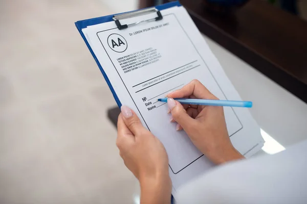 Primo piano della receptionist che tiene la penna mentre prende appunti — Foto Stock