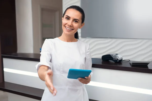 Recepcionista de cabelos escuros do cliente de saudação de clínica de beleza — Fotografia de Stock