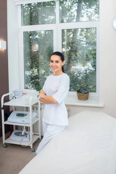 Berömd plastikkirurg står nära fönstret i hennes rymliga rum — Stockfoto
