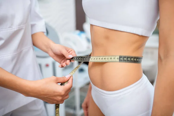 Close up of doctor measuring waistline of slim patient — Stock Photo, Image