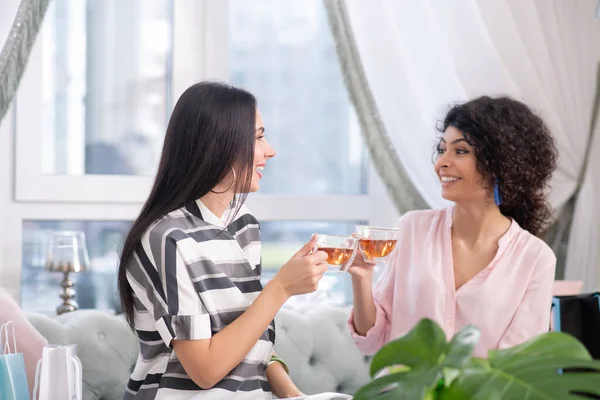 Две темноволосые женщины пьют чай и разговаривают — стоковое фото