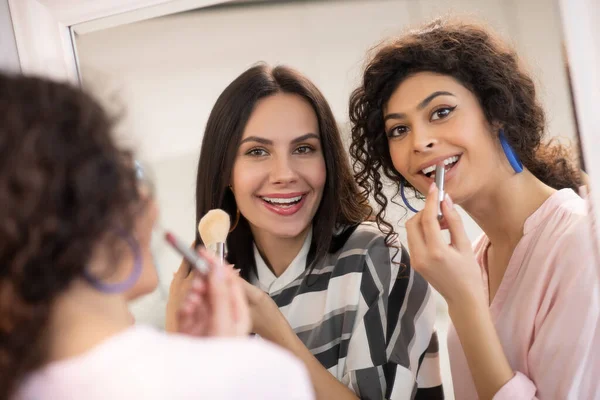 Две темноволосые женщины делают макияж и чувствуют себя потрясающе — стоковое фото
