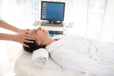 Dark-haired woman feeling relaxed while having spa therapy