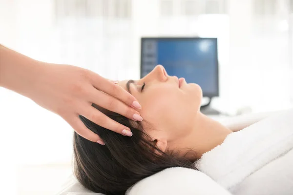 Brunette woman feeling relaxed while having facial massage — 图库照片