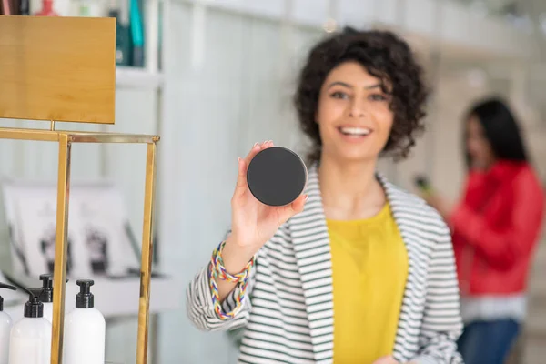 Mujer hermosa de pelo oscuro mostrando la máscara para el cabello — Foto de Stock