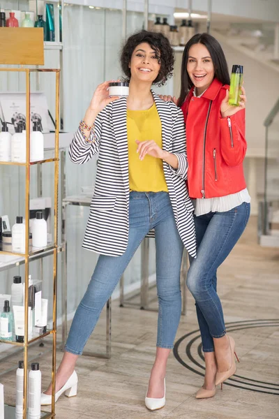 Two good-looking dark-haired girls choosing beauty products — Stockfoto