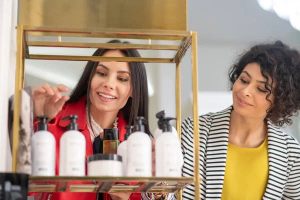 Two pretty women choosing body care products — Stockfoto