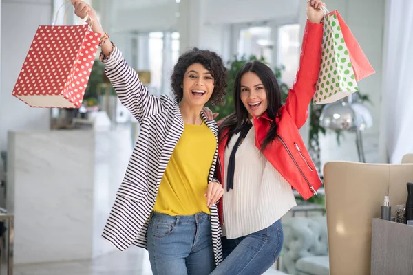 Two beautiful women feeling happy holding shopping bags — Stok fotoğraf