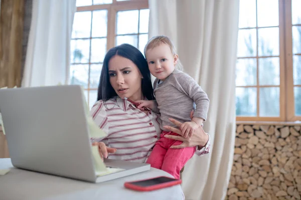 Mom busy working, daughter interfering, looking for attention — Stockfoto