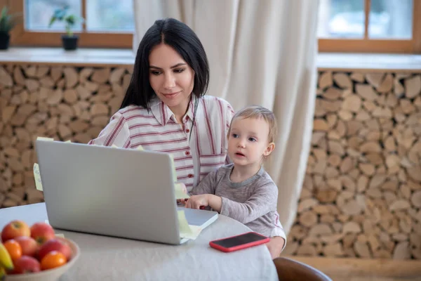 Joven mamá y su hija sentado en el ordenador portátil — Foto de Stock