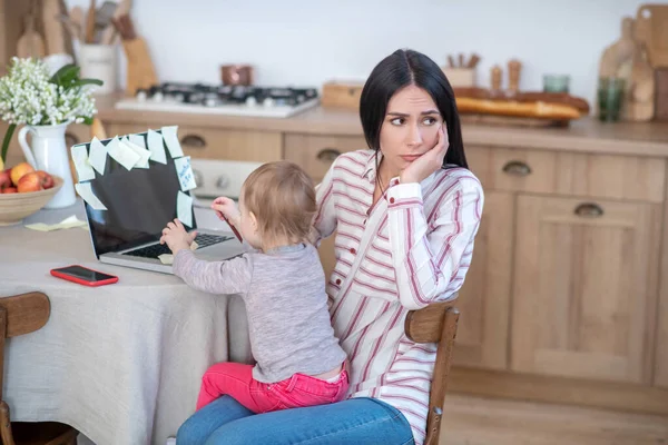 Stressed mom holding daughter, kid disturbing her — Stockfoto