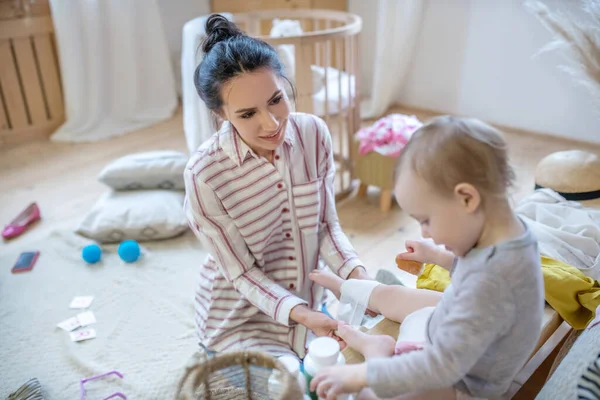 Mamá aplicando vendaje en la pierna de los niños, sonriendo —  Fotos de Stock