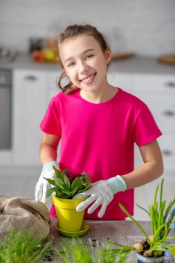Sarı tencerede koyu pembe menekşeli uzun saçlı kız..