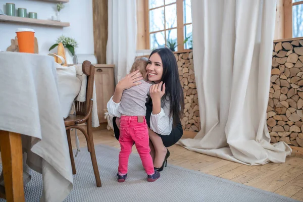 Working mom hugging her daughter and smiling — Stock Photo, Image