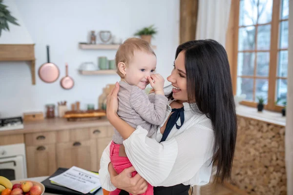 Junge Mutter hält Kind, beide lächeln glücklich — Stockfoto