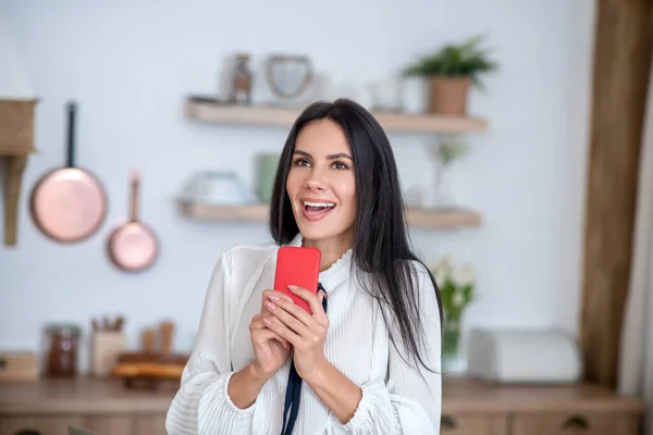 Jonge vrouw met rode smartphone, glimlach opgewonden — Stockfoto