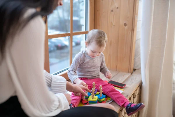 Jong mam en dochter zitten op vensterbank spelen leren spel — Stockfoto