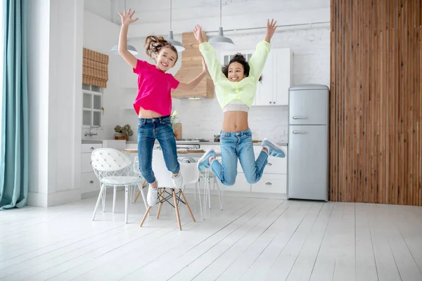 Dwie dziewczyny skaczą w kuchni uczucie niesamowite — Zdjęcie stockowe