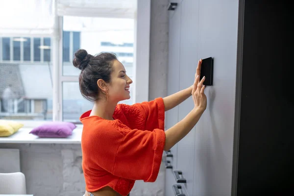 Mladá žena drží tablet u zdi, dotyková obrazovka — Stock fotografie