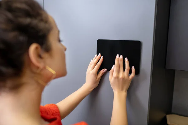 Mujer manos sosteniendo la tableta contra la pared gris —  Fotos de Stock