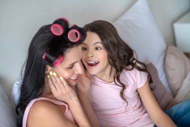 Pembe tişörtlü kız annesine hayranlıkla bakıyor.