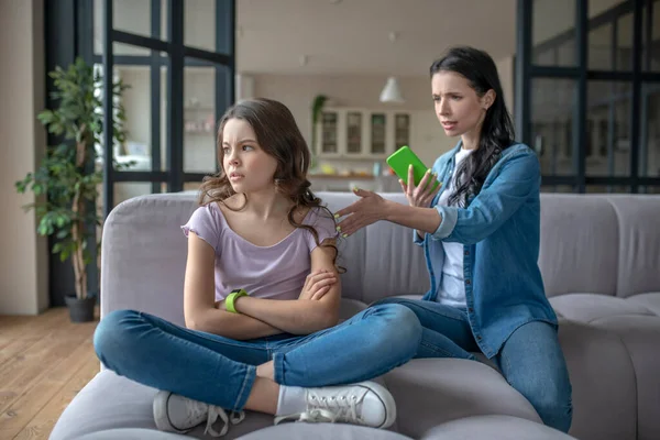 Mom in a jeans jacket talking to her daughter about internet dependence — Stock Photo, Image
