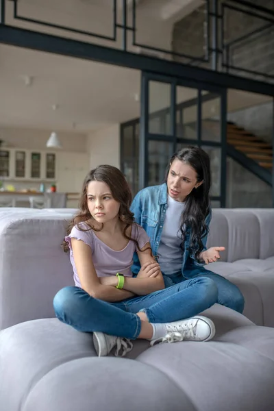 Adolescente morena sentada junto a mamá en una pose cerrada — Foto de Stock