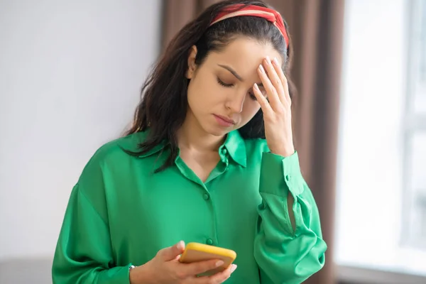 Jeune femme bouleversée regardant l'écran du smartphone . — Photo