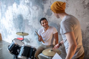 İki genç müzisyen prova sırasında konuşuyor.