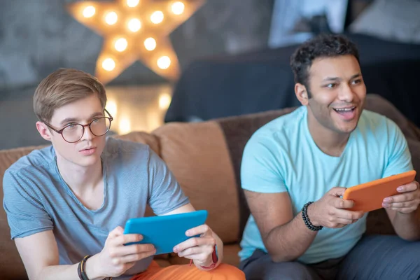 Två vänner som spelar TV-spel och ser involverade ut — Stockfoto
