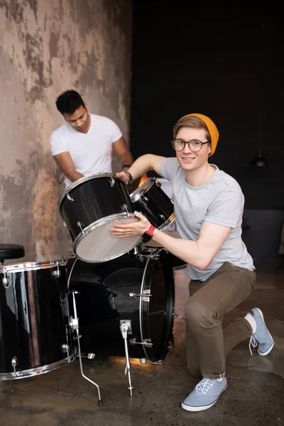 Young man in a red hat standing near the drums — Stock Photo, Image