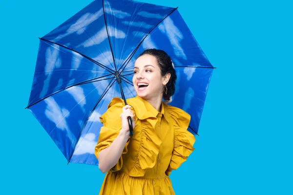 Woman in a mustard dress holding an umbrella — Stock Photo, Image